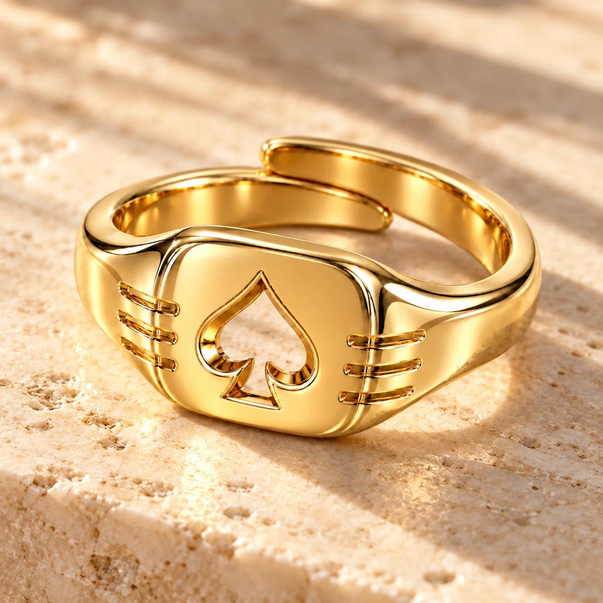 Aventurine Edge of Fortune Ring in gold, on warm stone in daylight