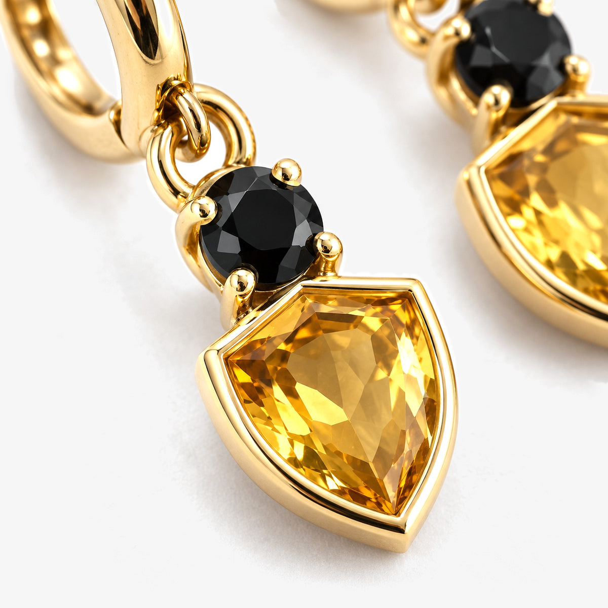 Badger Shield Huggie Earrings in gold, close-up