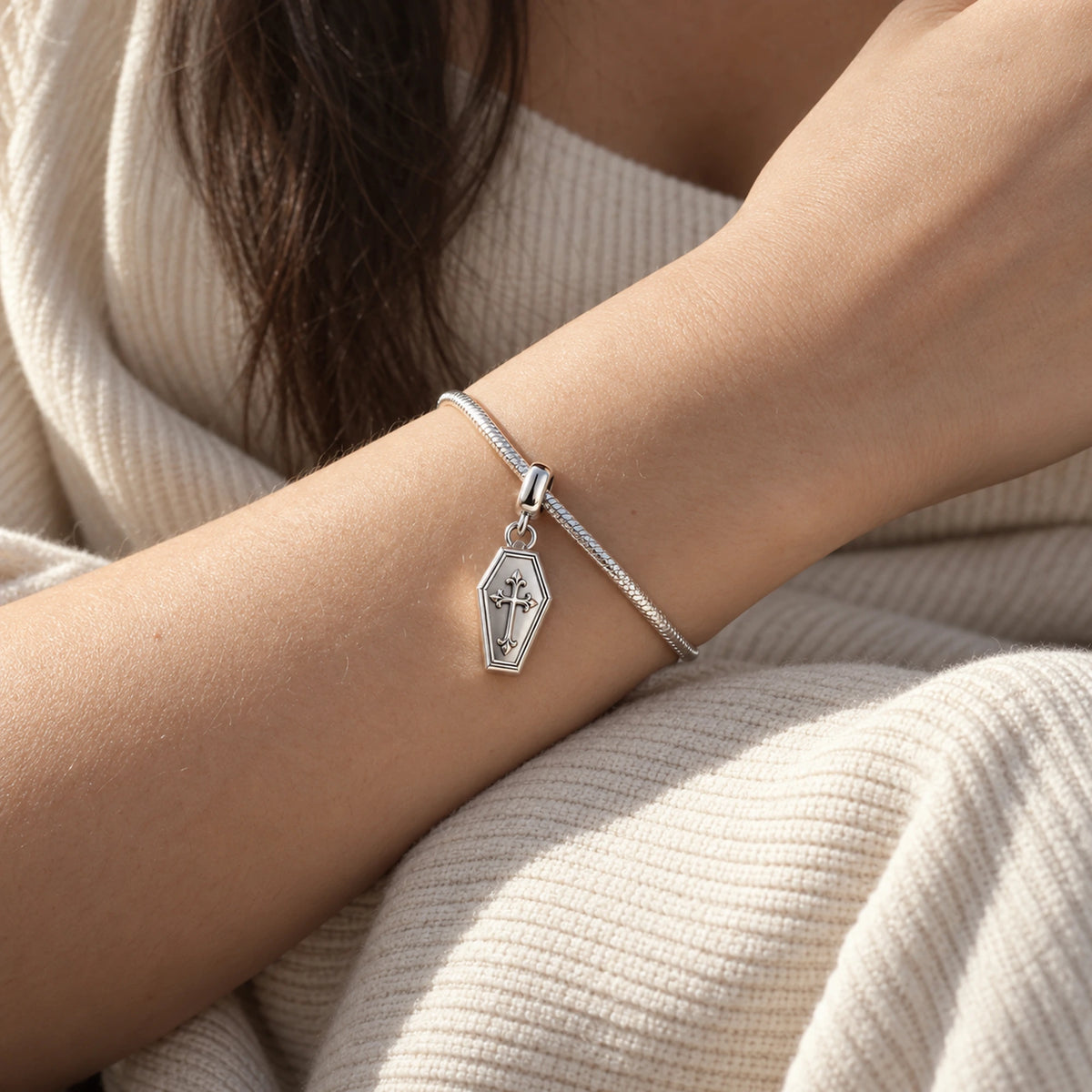 Coffin Cross Charm in silver, worn on a charm bracelet