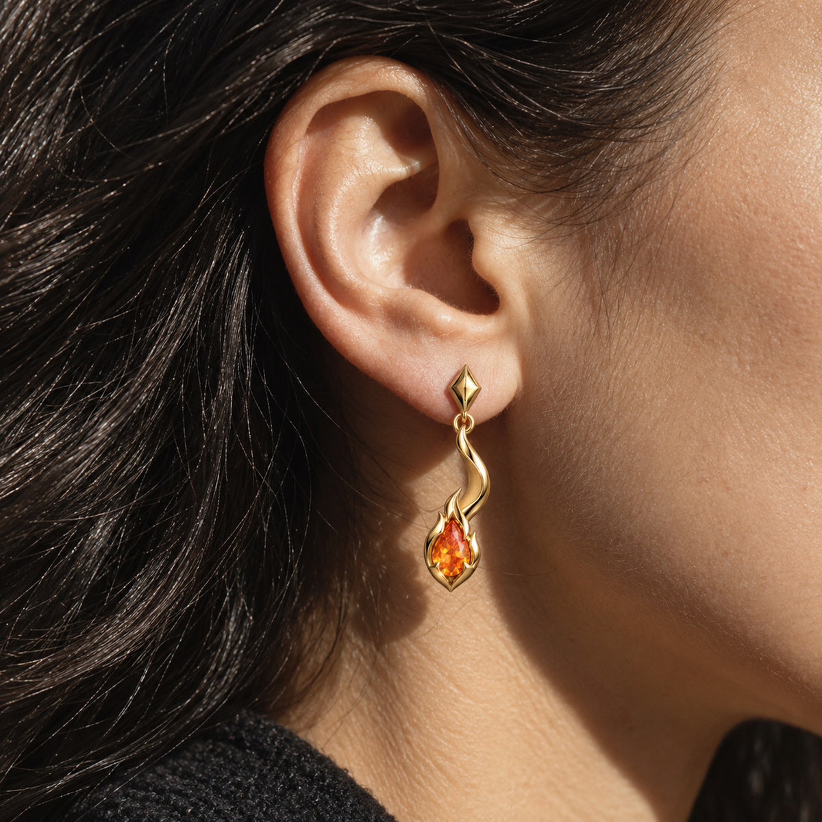 Tail Flame Earrings in gold, worn