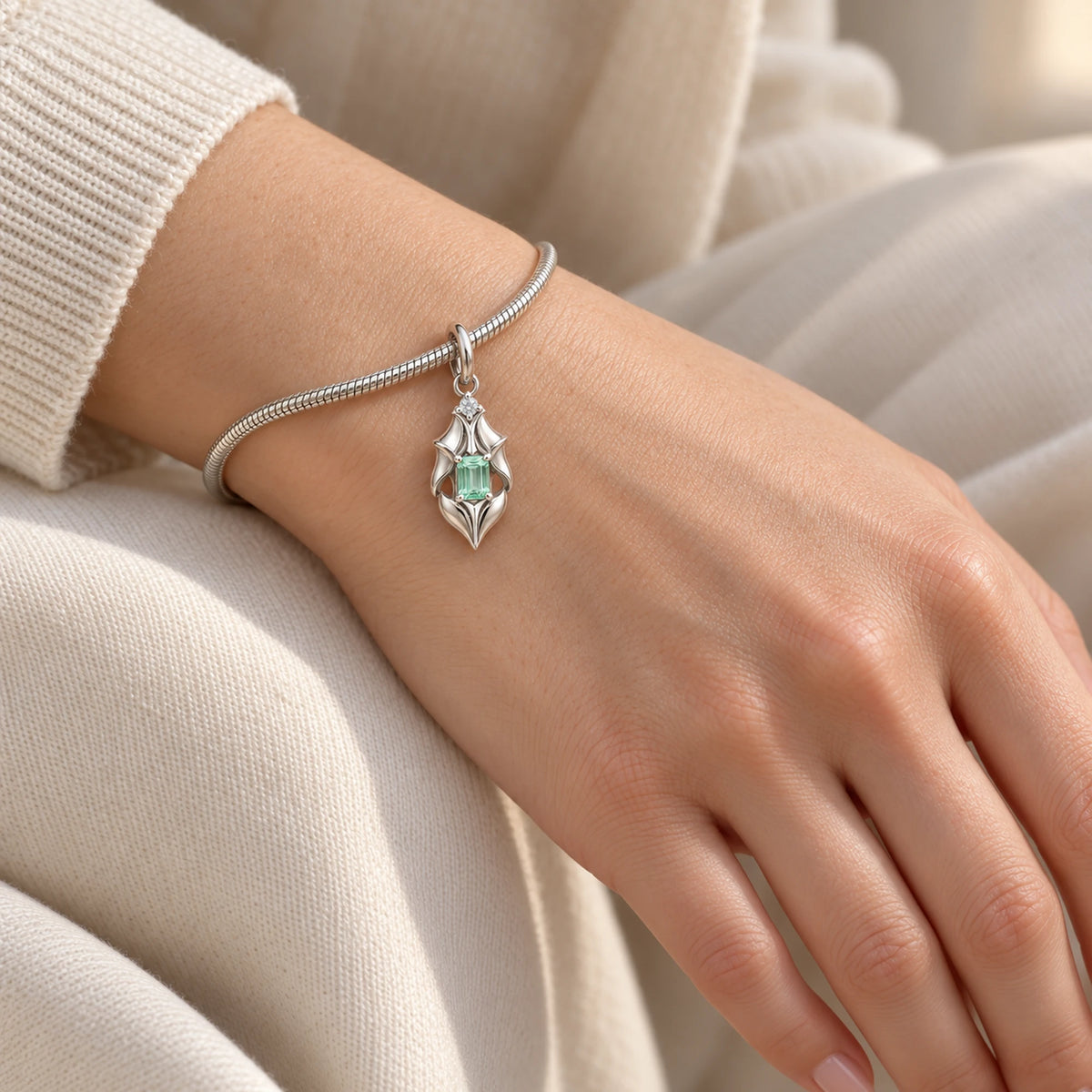 Firefly Armour Petal Charm in silver, on a charm bracelet on the wrist