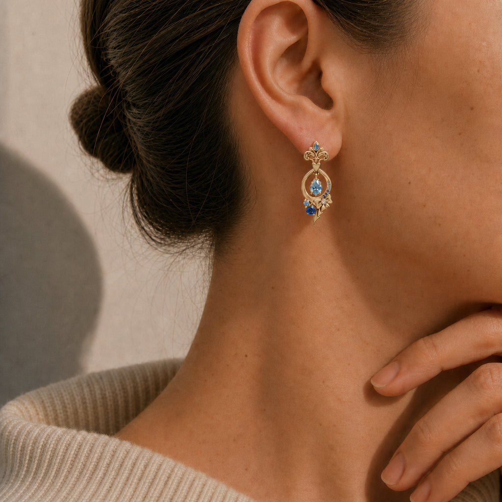Warm close-up model photo wearing Furina-inspired gold earrings with blue gemstones