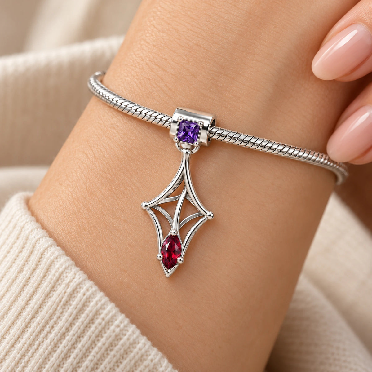 Kafka Little Strand Charm in silver, worn on a charm bracelet