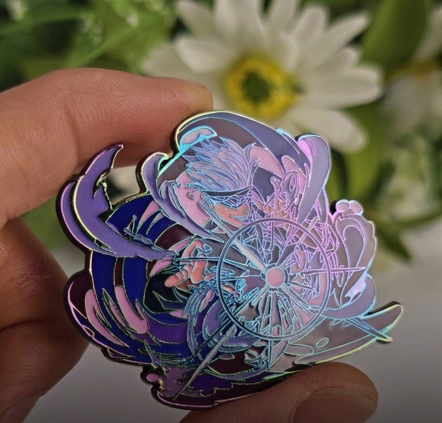 A holographic shiny enamel pin held in hand