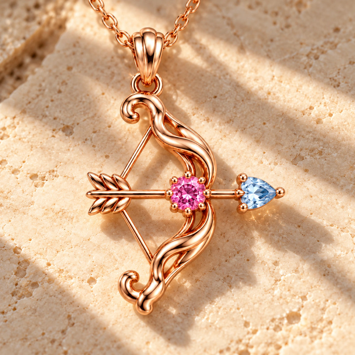 March 7th Bow and Arrow Necklace in rose gold, on warm stone in daylight