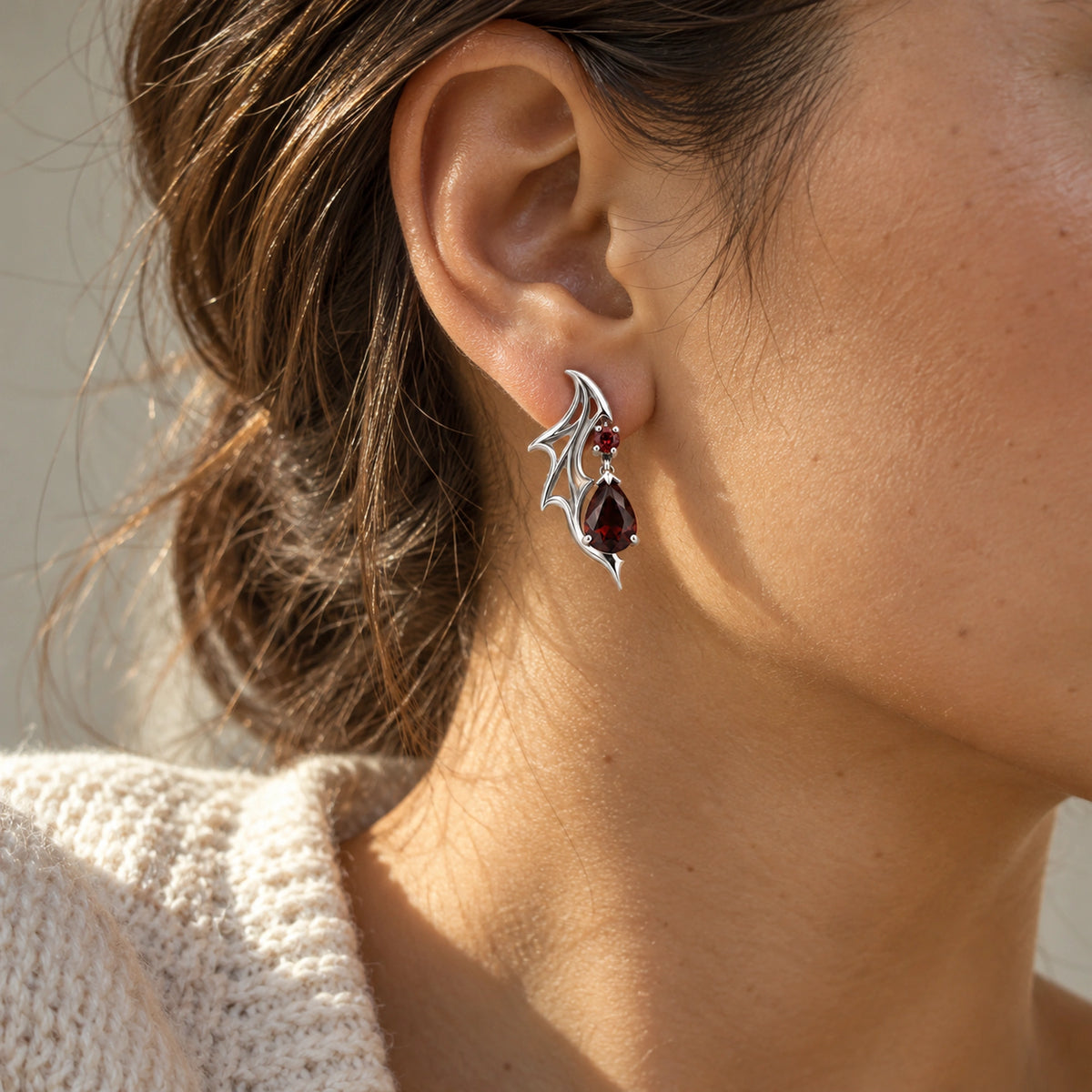 Crimson Wing Drop Earrings in Silver, worn on the ear