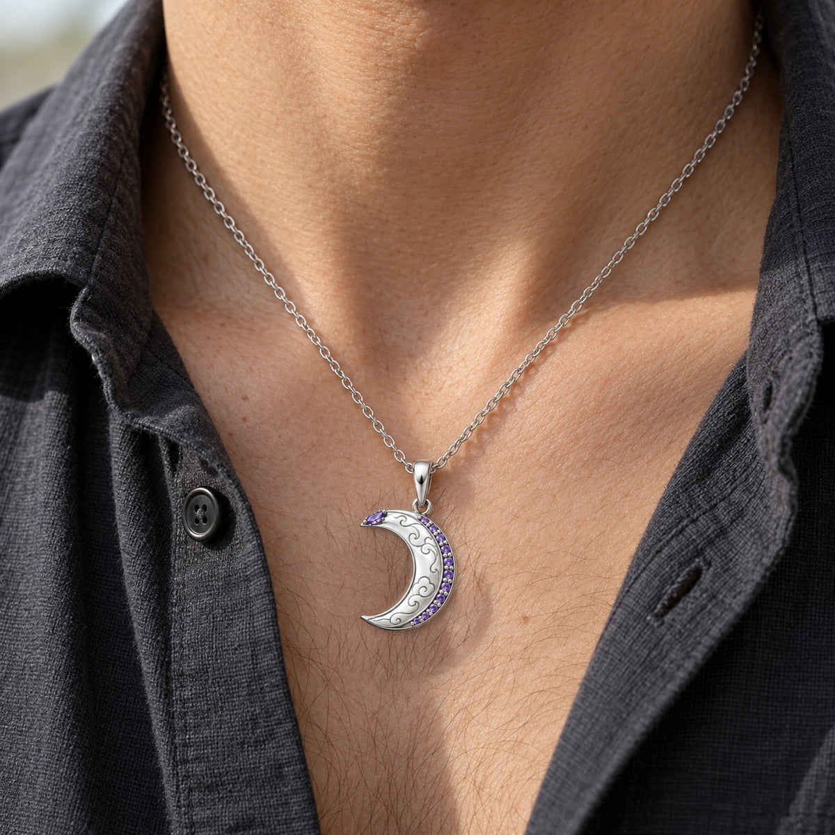 The silver crescent necklace from the Moon and Cat necklace pair, worn by a man
