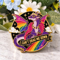 Pride Dragon enamel pin standing on a marble tabletop, supported discreetly from behind