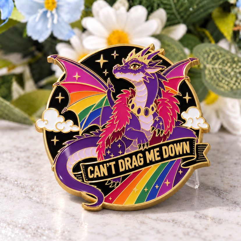 Pride Dragon enamel pin standing on a marble tabletop, supported discreetly from behind