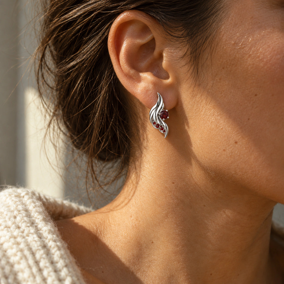 Seraph Wing Earrings in Silver, worn on the ear