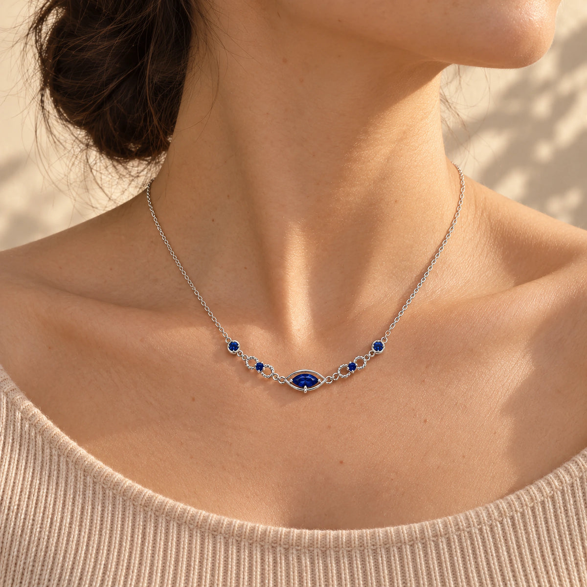 Six Eyes Infinity Necklace in silver, worn, three-quarter view; scale is illustrative